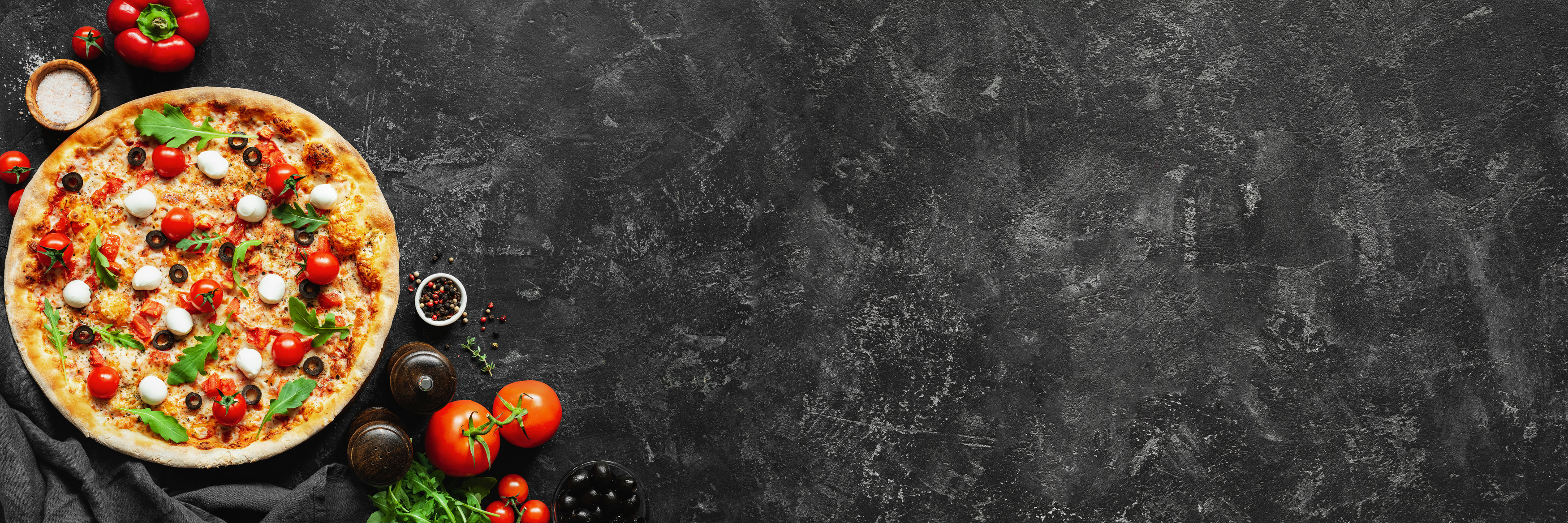 Italian pizza and pizza cooking ingredients on black concrete background